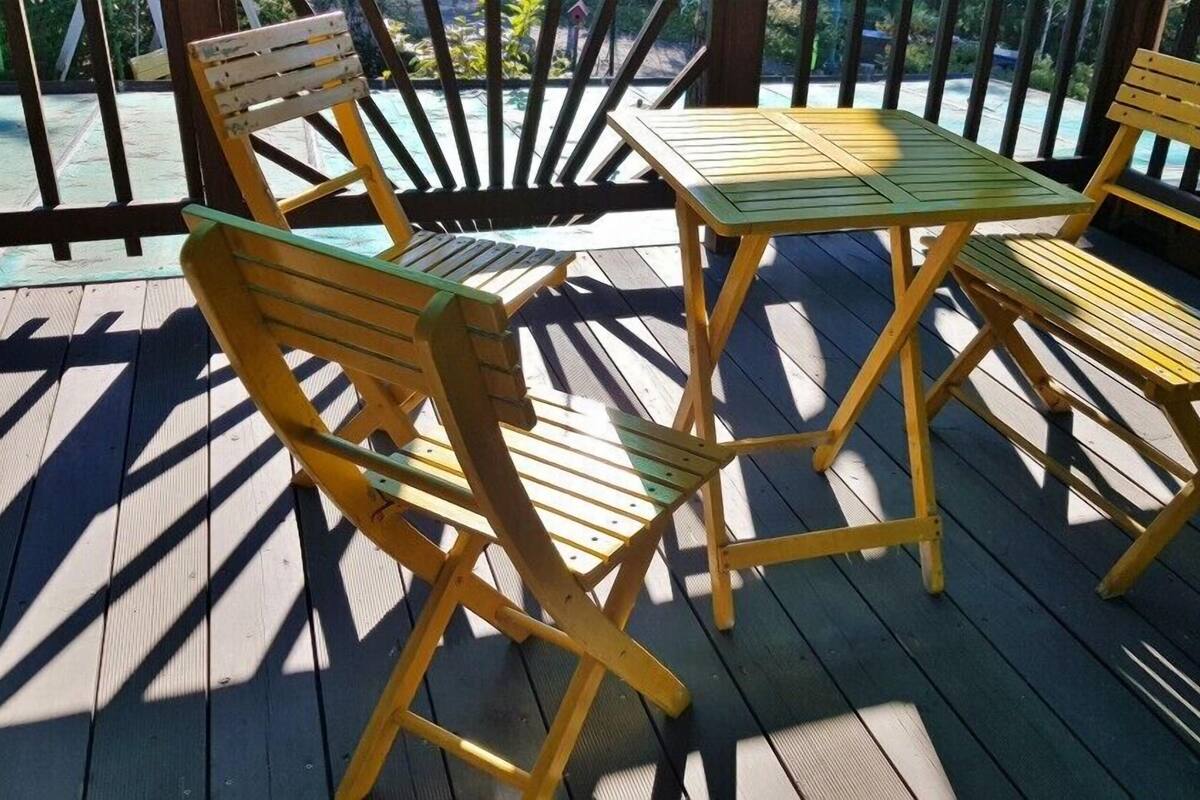 Eine Holzterrasse mit einem Tisch und zwei Stühlen.