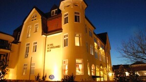 Un grand bâtiment jaune, doté d’une tour, et portant l’inscription « hôtel ».