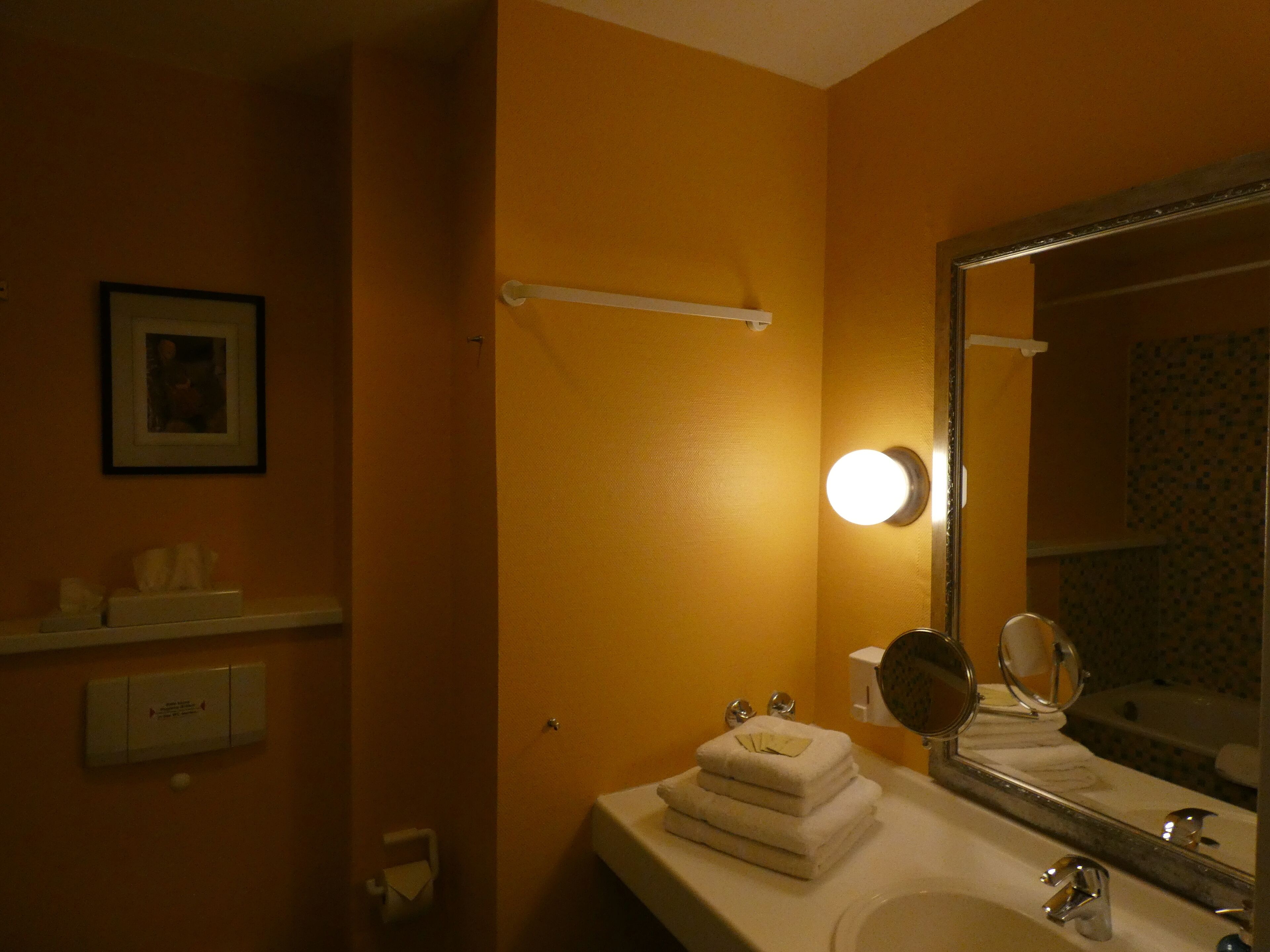A bathroom with a sink, mirror, and towel rack.