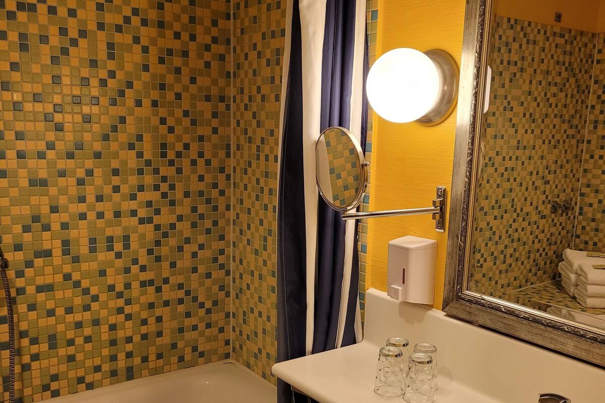 A bathroom with a bathtub, a sink, and a mirror.