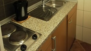 A kitchen with a granite countertop, stainless steel sink, and a black coffee maker.