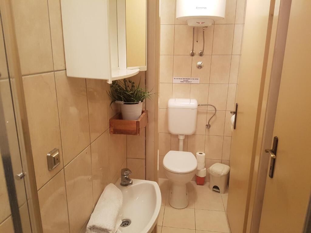 Un baño pequeño con lavamanos, inodoro y ducha.