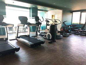 A gym with treadmills, elliptical machines, and weight equipment.