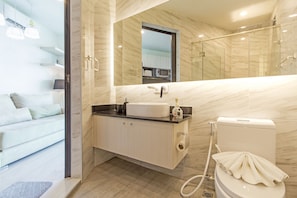 A modern bathroom with a toilet, sink, and shower.