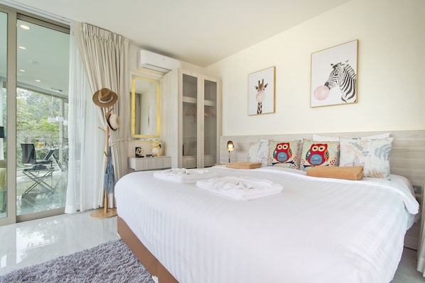 A bedroom with a large bed, a wardrobe, a mirror, and a window with curtains.