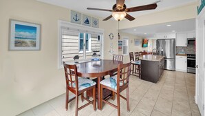 A spacious kitchen with a central island, a dining area with wooden chairs, and a ceiling fan. - ICONIC SEASIDE HEIGHTS BEACH HOUSE (Seaside Heights)