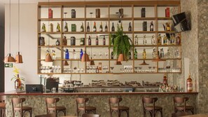 A bar area with shelves of bottles and glasses, a counter, and bar stools. - Dela Inn Andradas (Andradas)