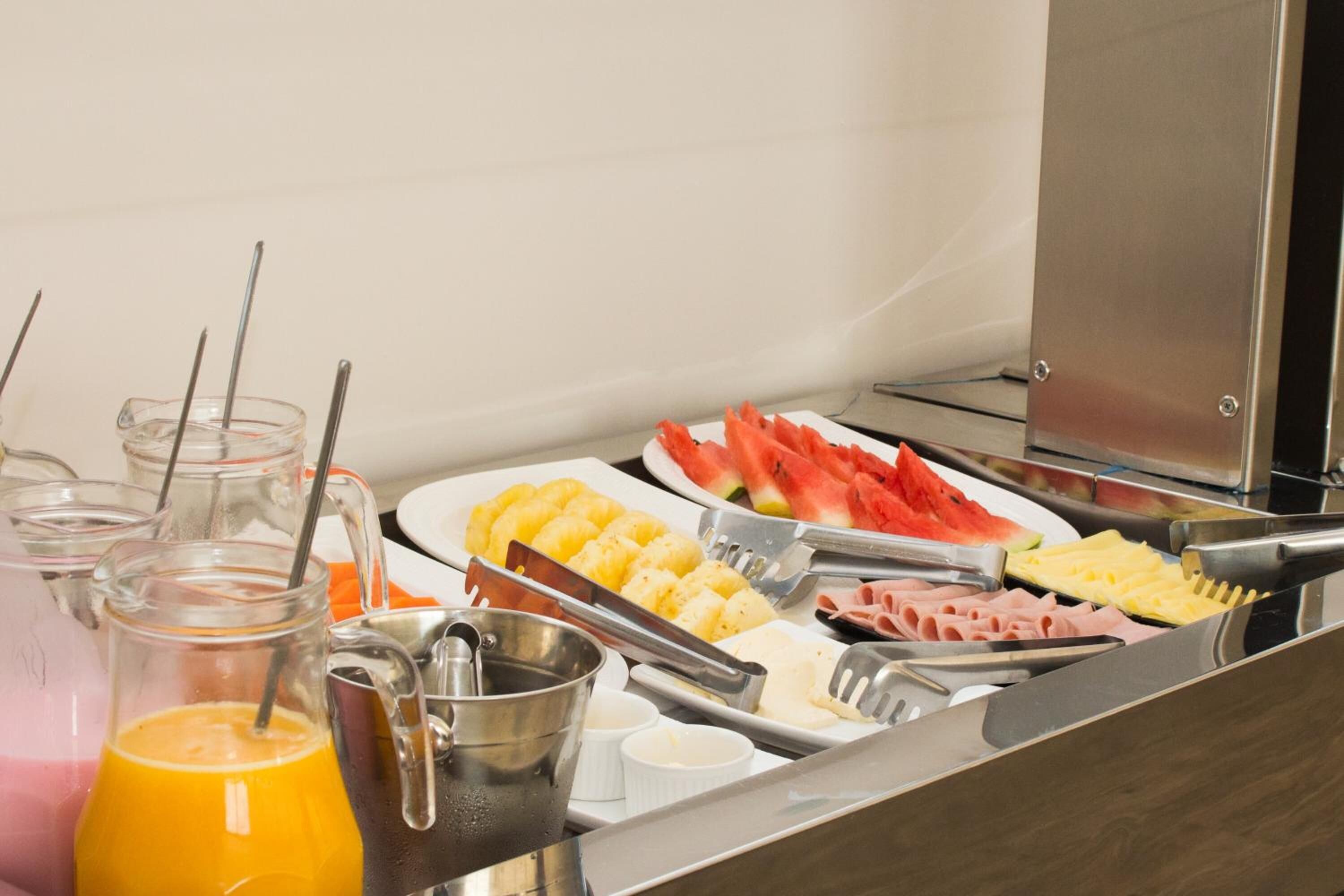 Un buffet con diversi cibi, tra cui frutta, verdura e carni.