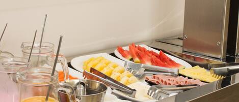 Un buffet con diversi cibi, tra cui frutta, verdura e carni.