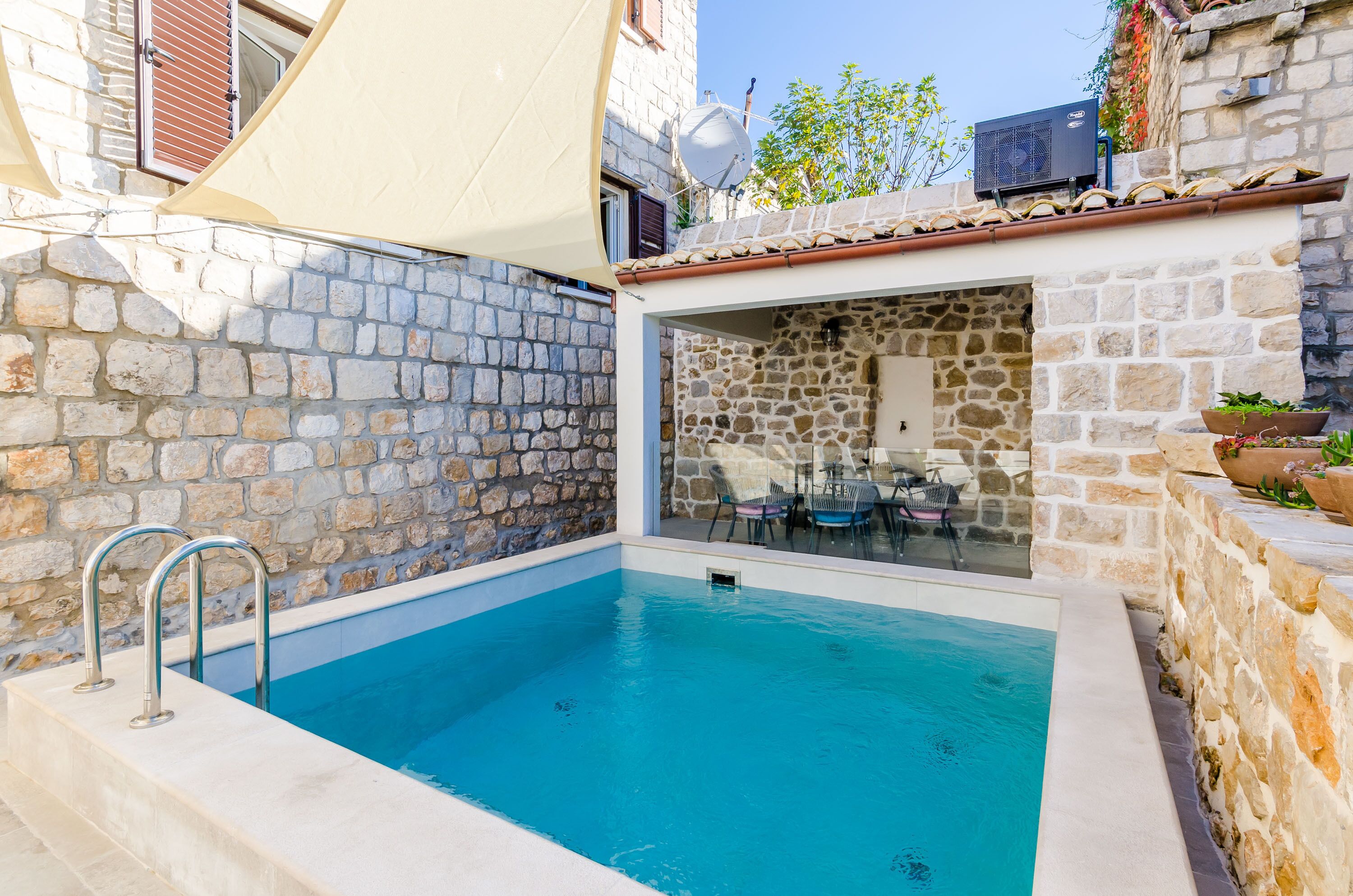 Una piscina con paredes de piedra y cerramiento de vidrio.