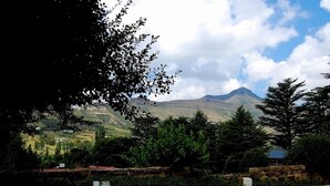 A parking area with a mountain view. - Stonehaven Guest House (Clarens)