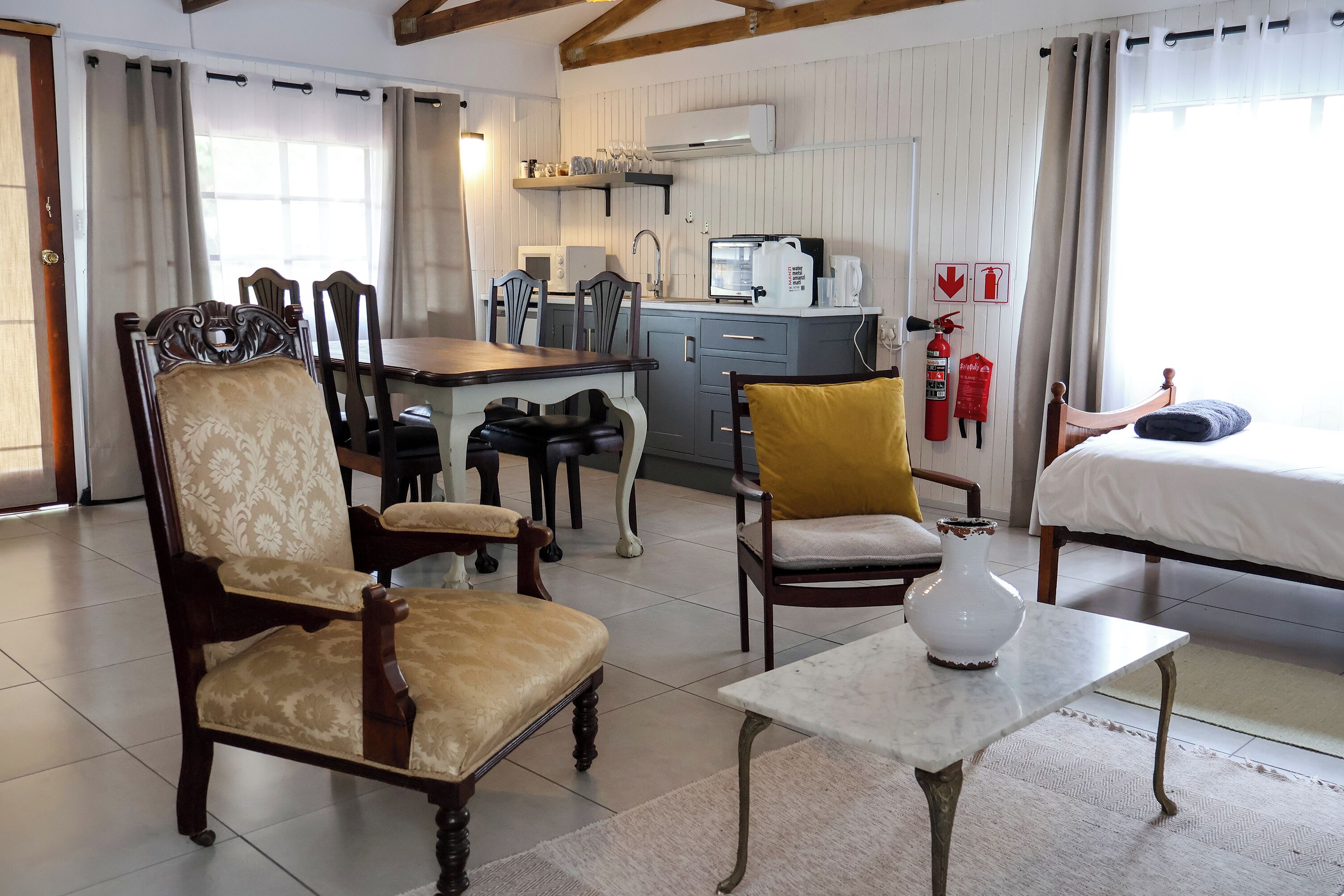 A cozy room with a dining area, a bed, and a kitchenette.