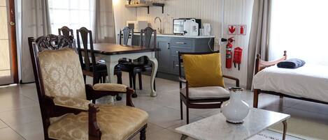 A cozy room with a dining area, a bed, and a kitchenette.