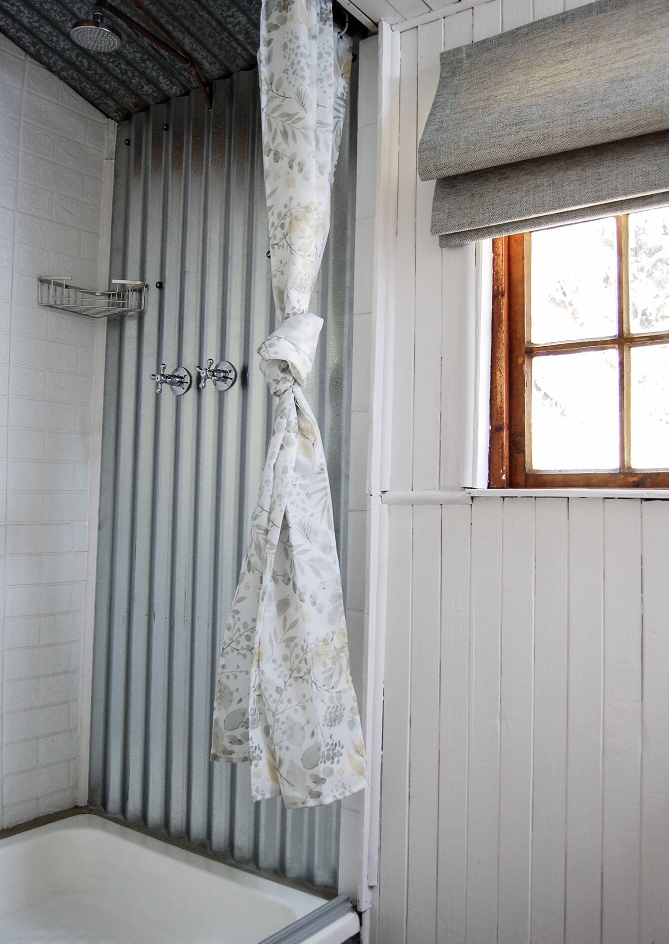 A bathroom with a shower curtain, a window, and a bathtub.