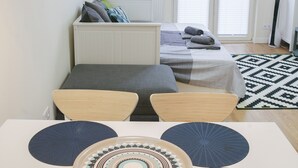 Une chambre à coucher moderne avec un lit, une table de chevet et un coin repas comprenant une table et des chaises.