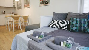 Une chambre à coucher moderne avec un lit, des oreillers et une table de chevet sur laquelle sont posés des articles de toilette.