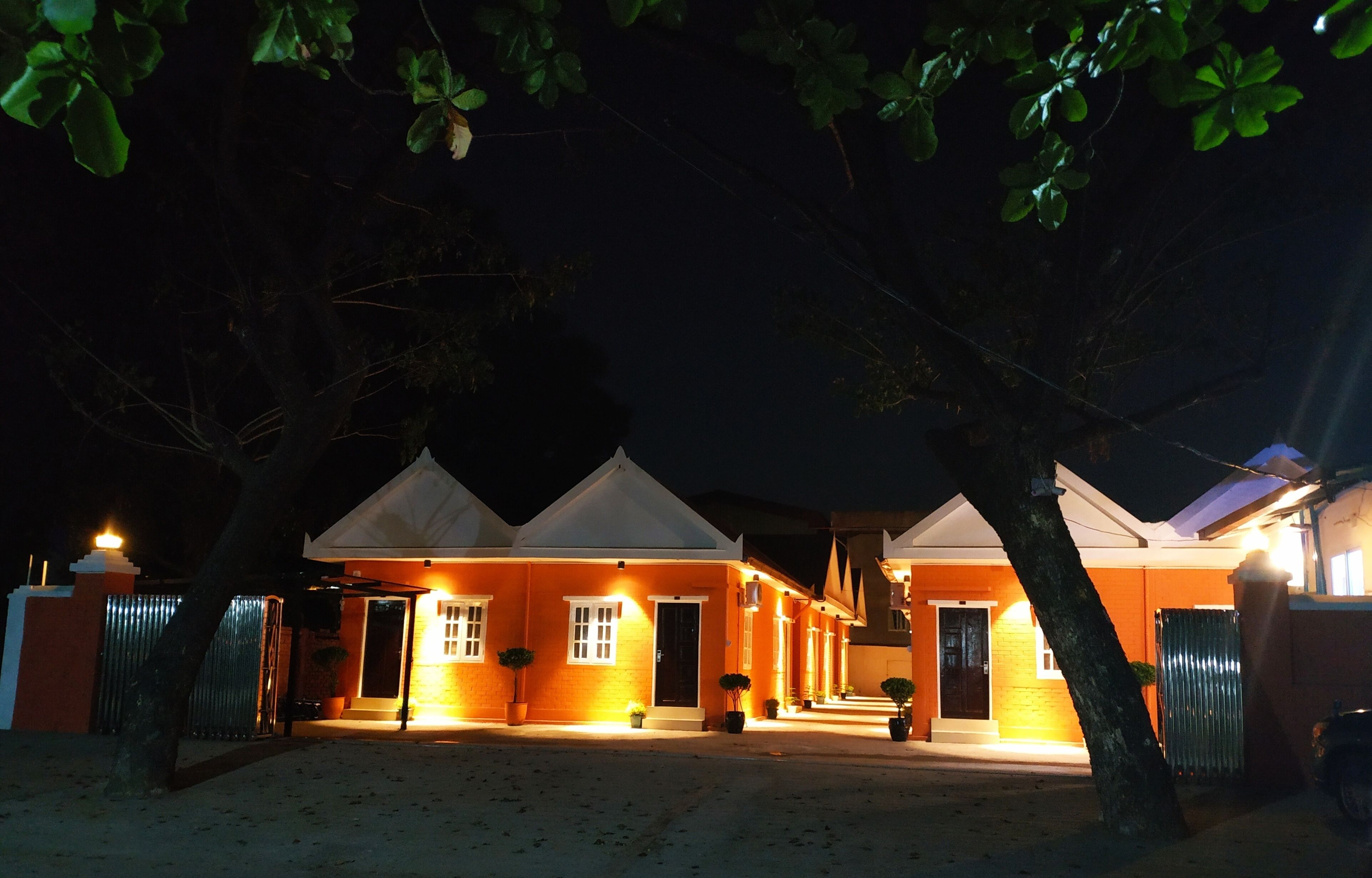 Uma fileira de casas com entrada bem iluminada e portão na entrada.