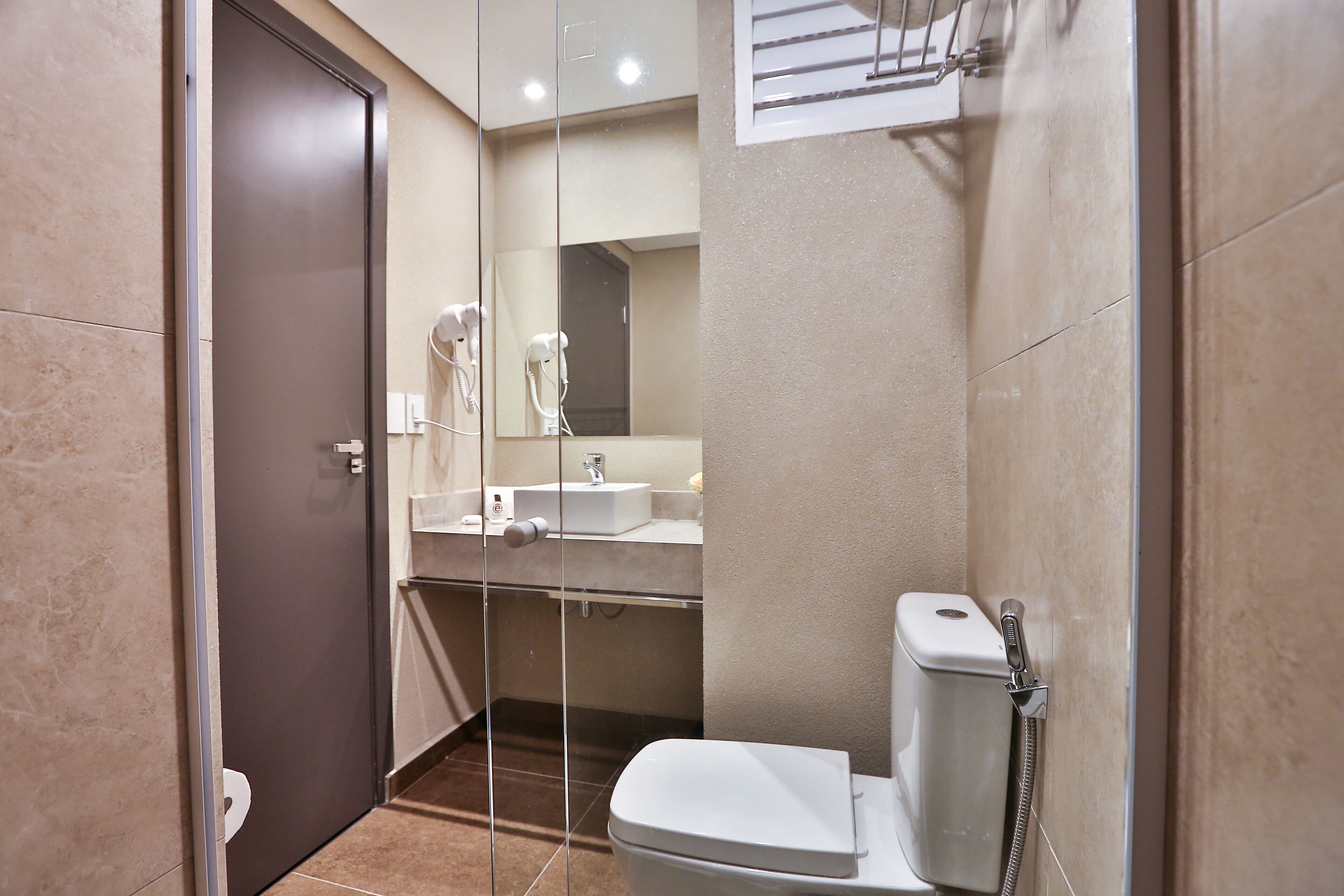Een moderne badkamer met toilet, wastafel en douche.