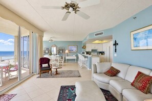 A spacious living area with a balcony, a dining area, and a kitchen. - Surf And Racquet 101 3 Bedroom Condo by RedAwning (New Smyrna Beach)