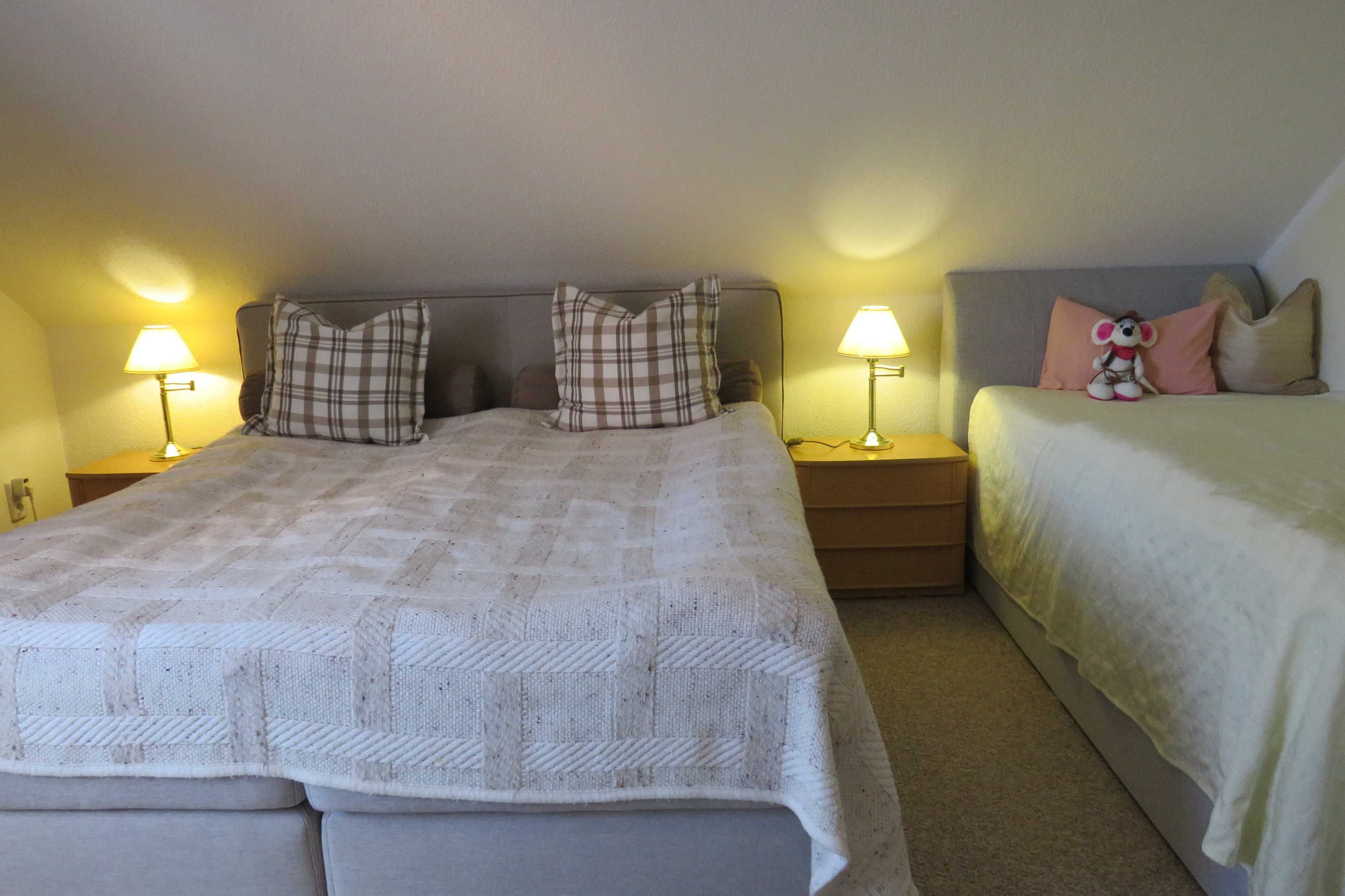 A bedroom with a large bed, two bedside tables, and a nightstand.