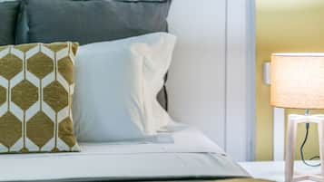 A neatly made bed with patterned pillows and a bedside lamp.