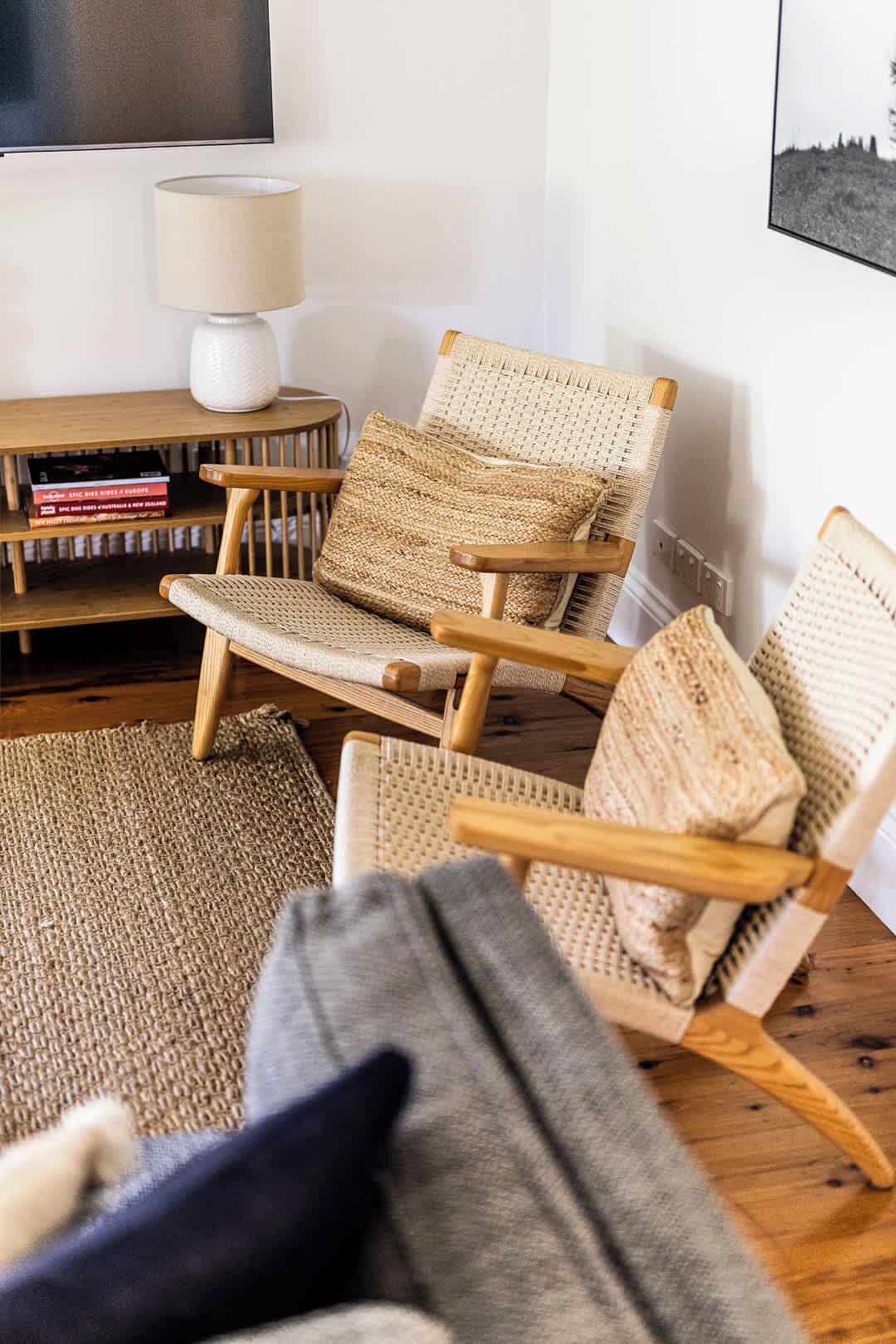 A living room with a sofa, two armchairs, a coffee table, a TV, and a bookshelf.