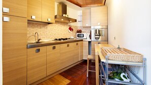 A modern kitchen with wooden cabinets, a microwave, a stove, and a sink.