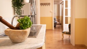 A kitchen with a marble countertop, a mortar and pestle, a sink, and a potted plant. - Family Apartments Angeli (Genoa)