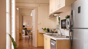 A modern kitchen with stainless steel appliances, a built-in dishwasher, and a small island with a sink. - Family Apartments Angeli (Genoa)