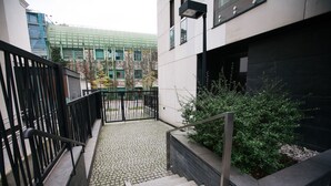 A modern building with a staircase leading to a gated entrance. - Warsaw Concierge Vistula Apartment (Warsaw)