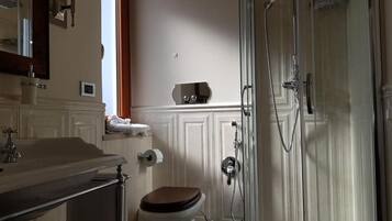 Een badkamer met toilet, wastafel en douche.