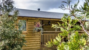 A wooden cabin with a balcony, a window, and a sign that reads "LAUREL". - Laurel Lodge - Log Cabin - St Florence (Tenby)