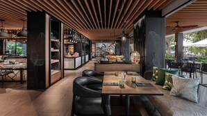 A modern interior with a wooden ceiling, black leather seating, and a central dining table. - Four Points by Sheraton Phuket Patong Beach Resort (Patong)