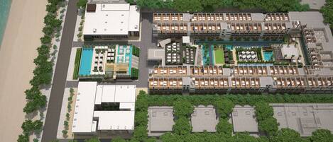 A resort with multiple buildings, a swimming pool, and a beach.