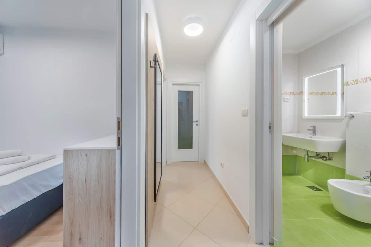 A modern bathroom with a shower, toilet, and sink.
