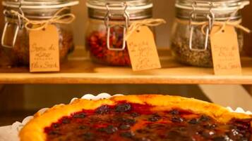 Three jars of preserves on a shelf with a pie in the foreground.