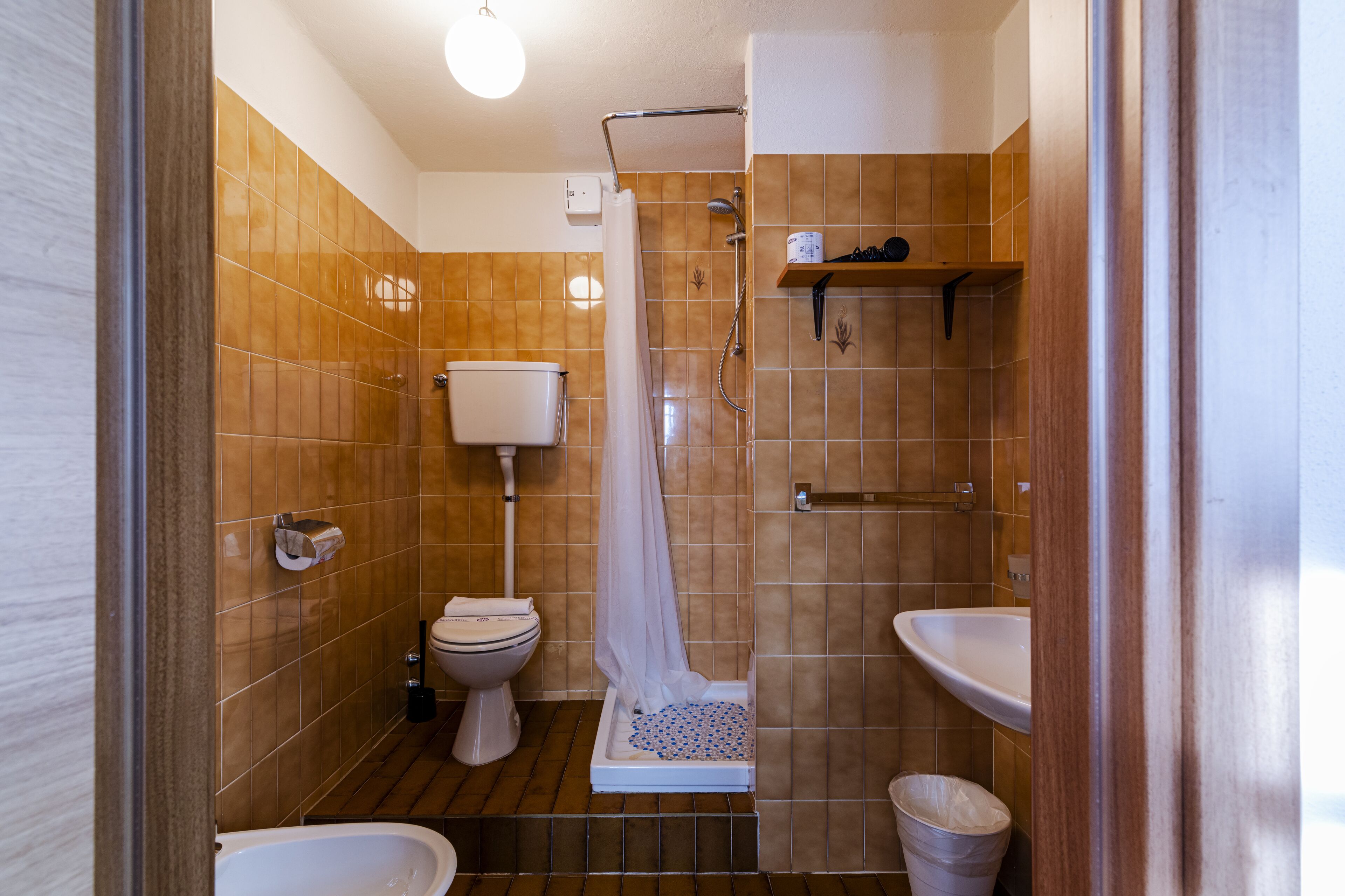 Un baño con ducha, inodoro, bidé y lavabo.