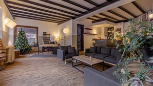 A modern living room with a wooden floor, dark sofas, a coffee table, and a Christmas tree. - Hotel Dufour (Macugnaga)