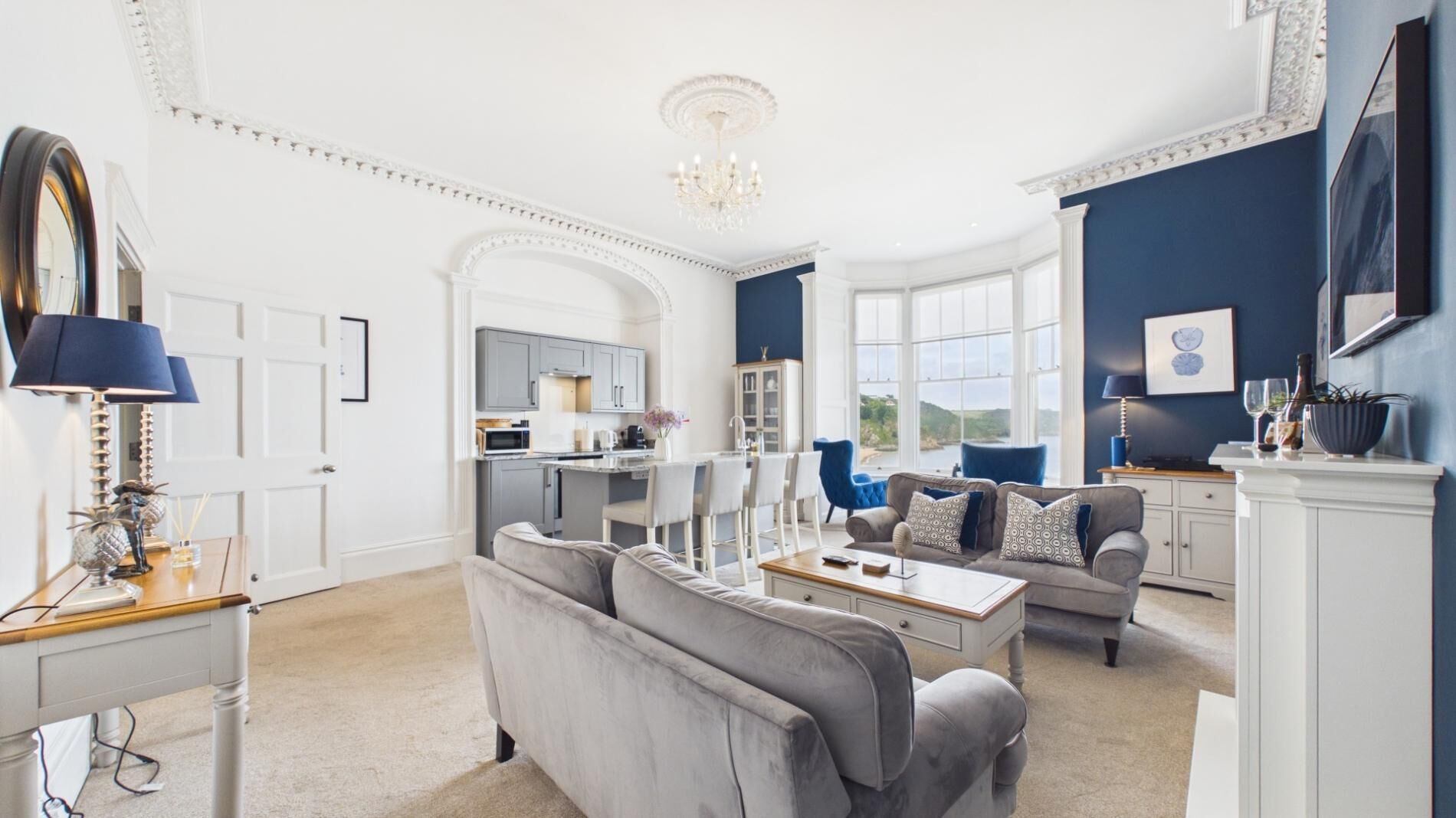 A spacious living room with a dining area, kitchen, and a view of the outdoors.