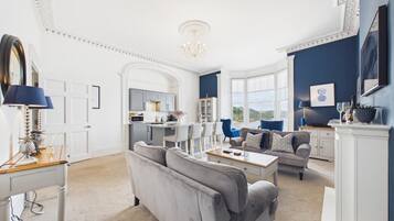 A spacious living room with a dining area, kitchen, and a view of the outdoors.