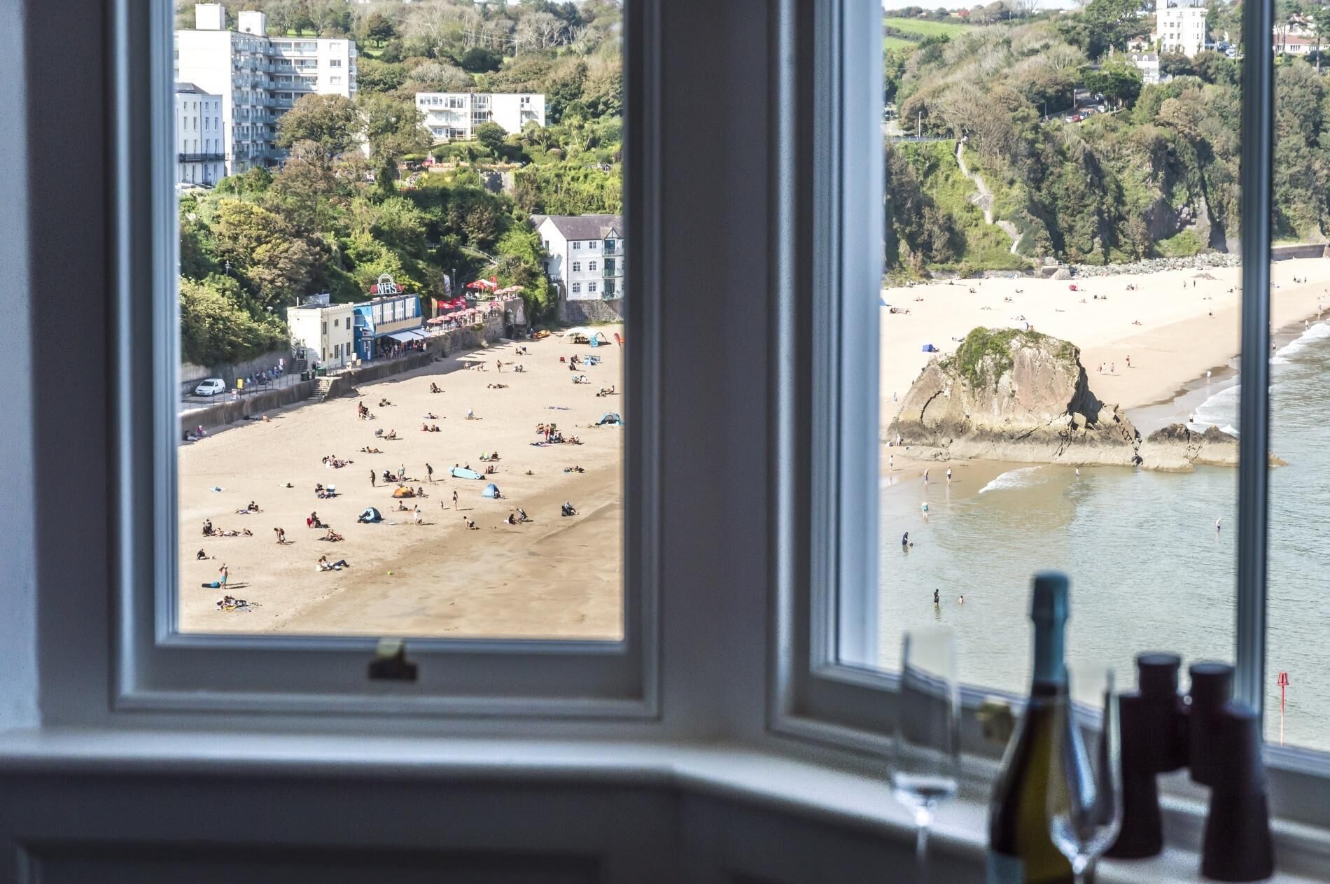 Vista de una playa con gente y edificios al fondo.