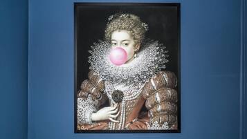 A framed portrait of a person in historical attire with a ruffled collar and elaborate jewelry.