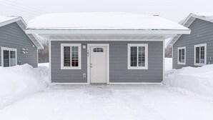 A two-story house with a covered porch and a white door.