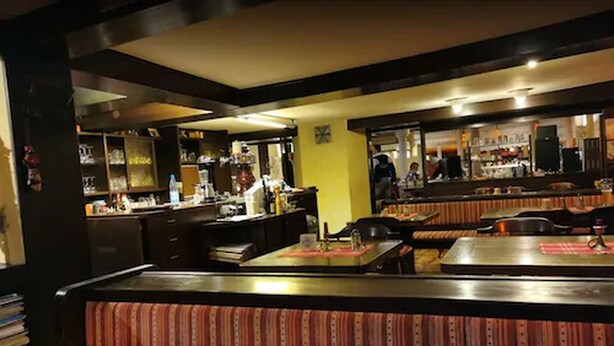 Un restaurante con cabinas y una zona de bar.