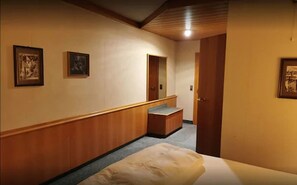 A hotel corridor with wooden paneling, a bench, and framed artwork on the walls. - Hotel Ritter Sakira (Wallduern)