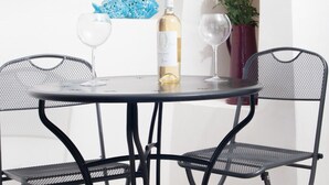 A table with two chairs, a bottle of wine, and two glasses. - Giùasud (Ostuni)