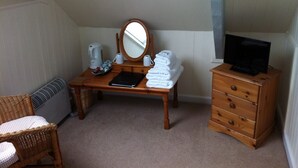 A small, cozy room with a wooden desk, a mirror, a dresser, and a chair. - The Stanley (Penzance)