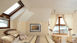 A bedroom with a bed, a window, a chair, and a framed picture on the wall. - The Stanley (Penzance)