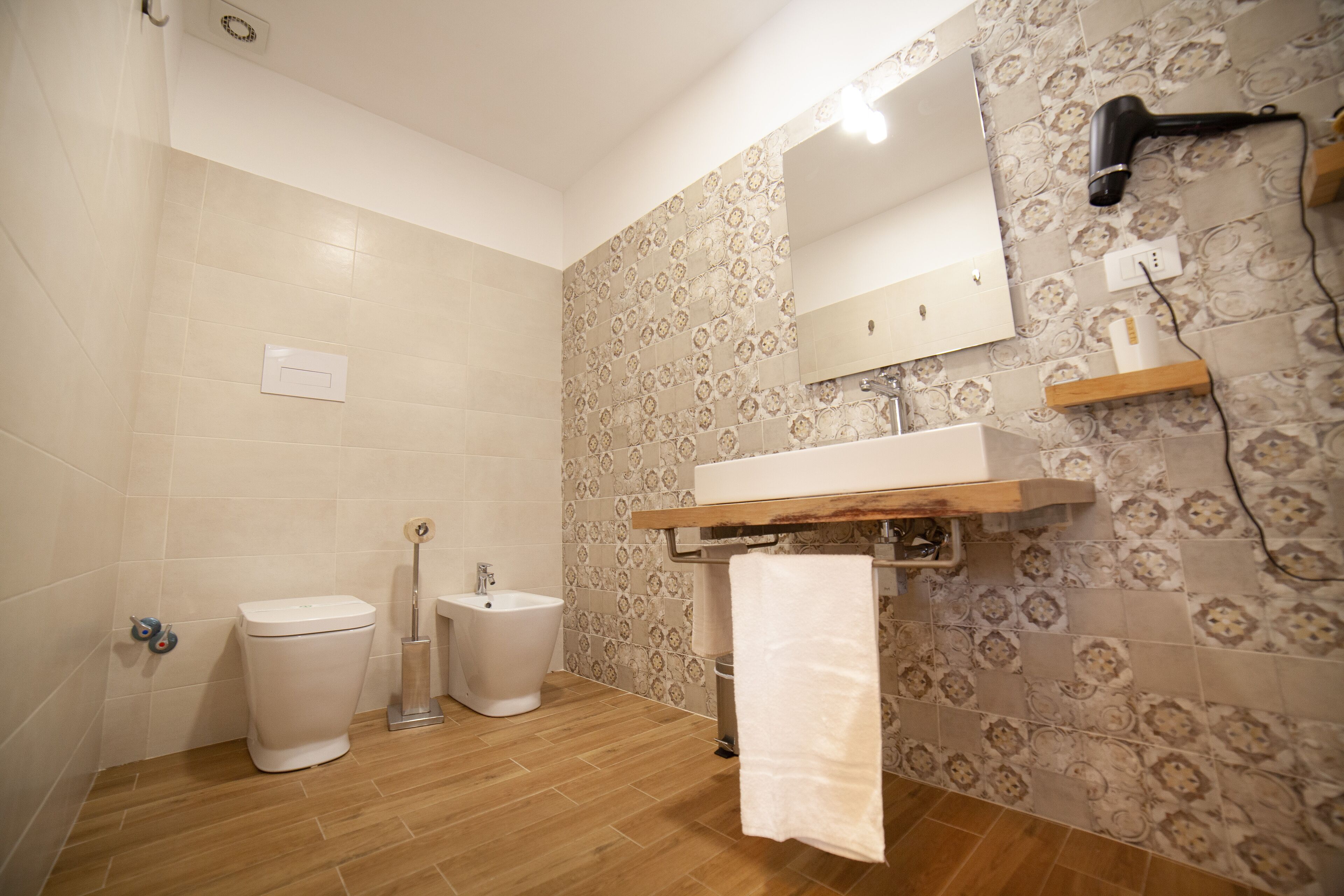 Een badkamer met toilet, bidet en wastafel.