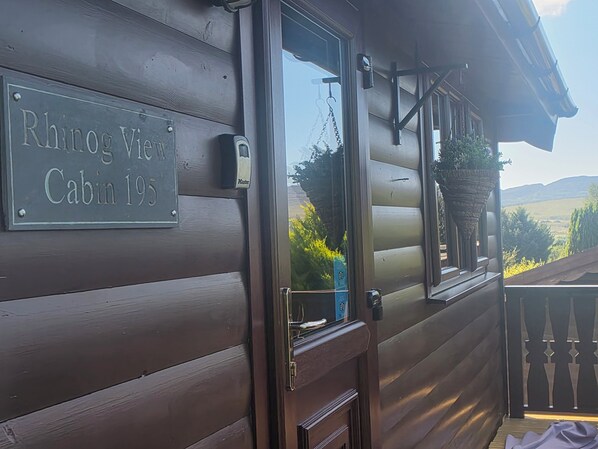 En stuga av trä med en skylt där det står ”Rhino View Cabin 19S”.
